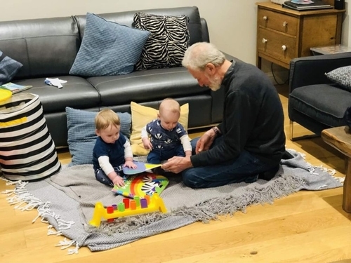 Young twins play on the floor in child-friendly holiday cottage Gwelmor