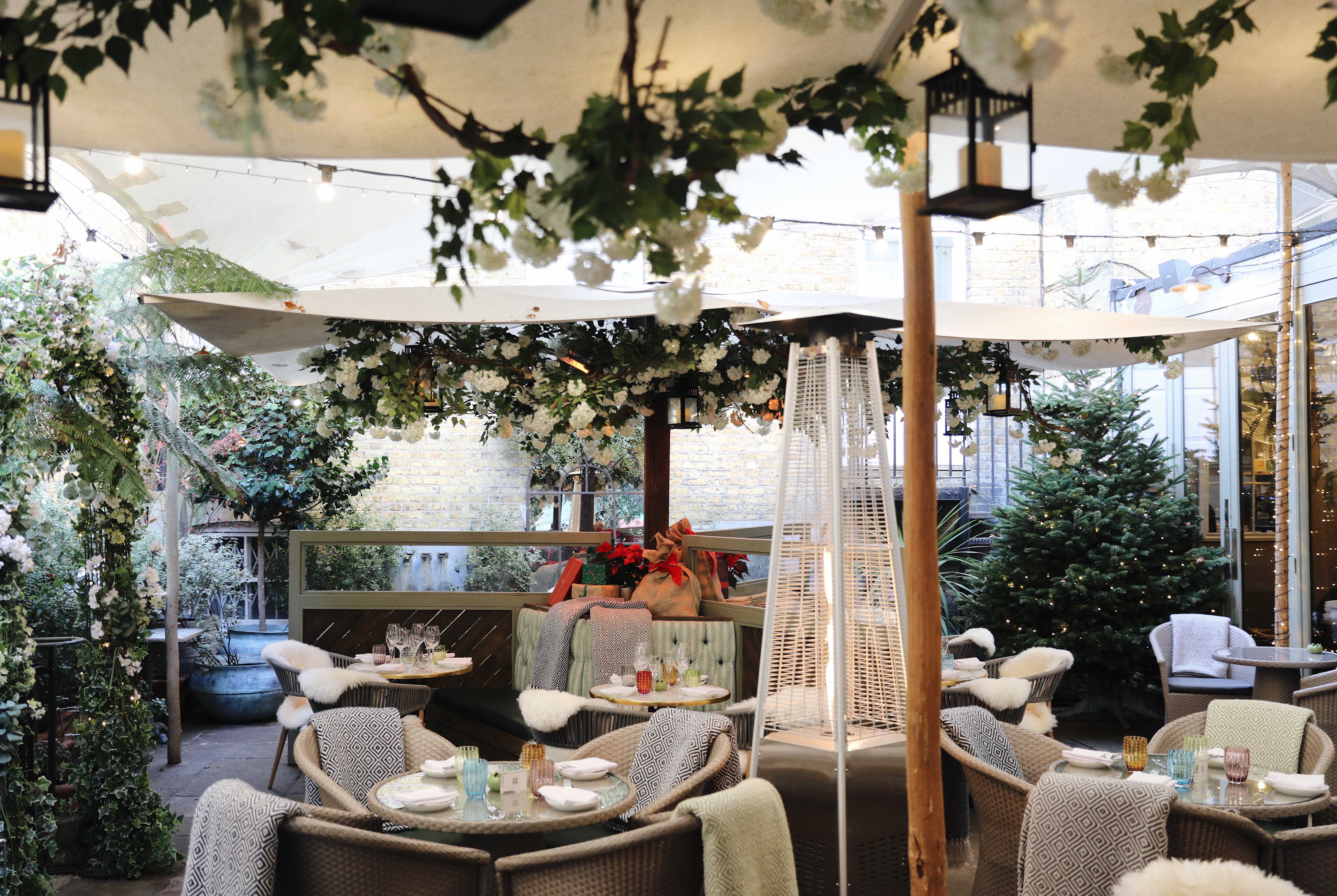 Outside seating at Stanley's Chelsea with blossom covered umbrellas and orange trees