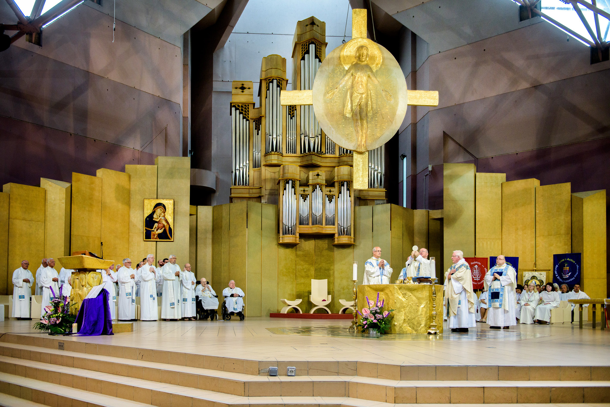 Bishop Richard and many priests are seen in the sanctuary of the Eglise Ste Bernadette, at the moment of the Elevation of the Host.