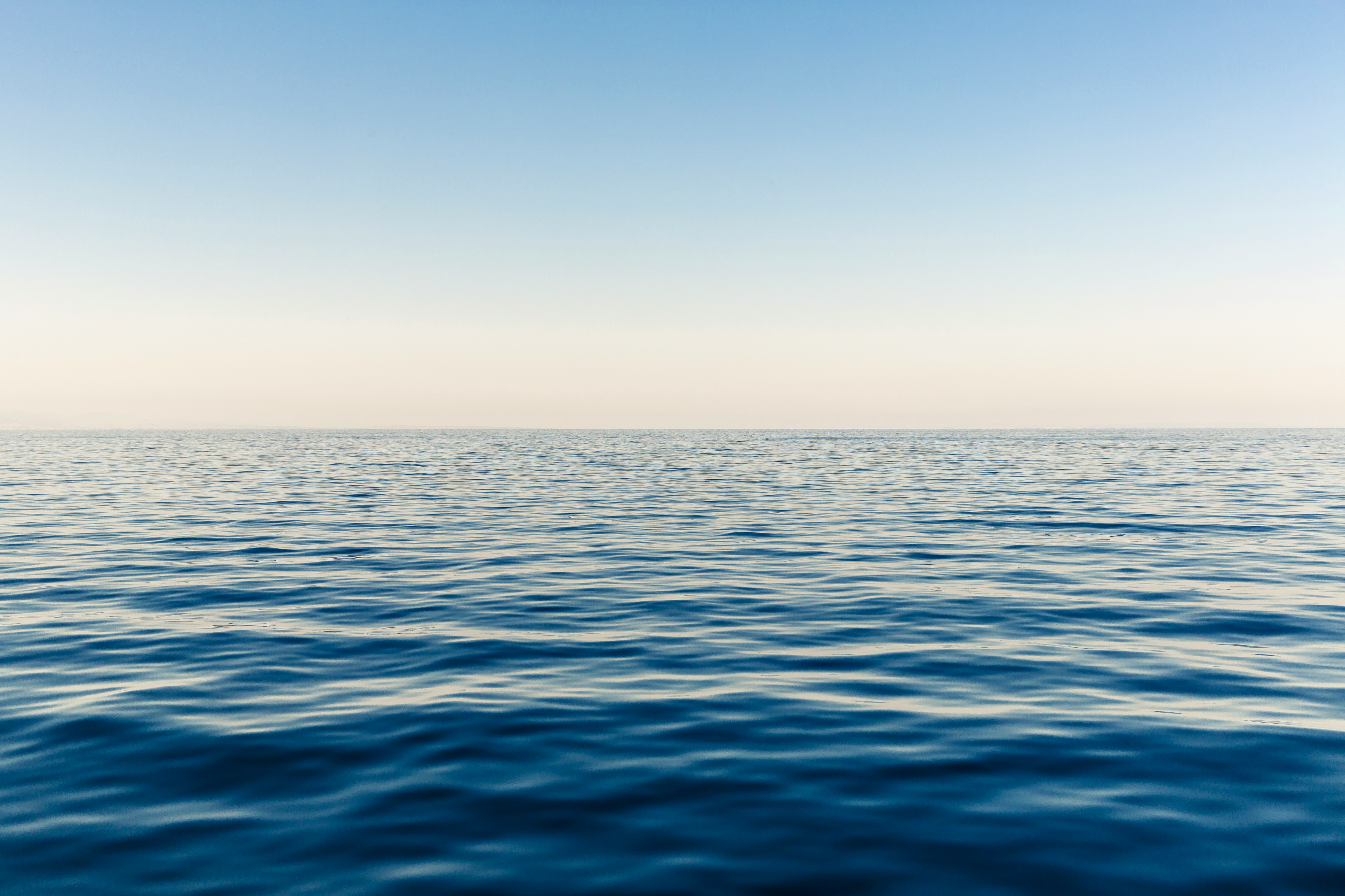 Photo shows a calm sea, looking towards a pale horizon