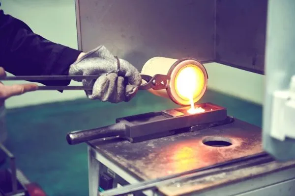 Technician using a torch to assay a gold bar