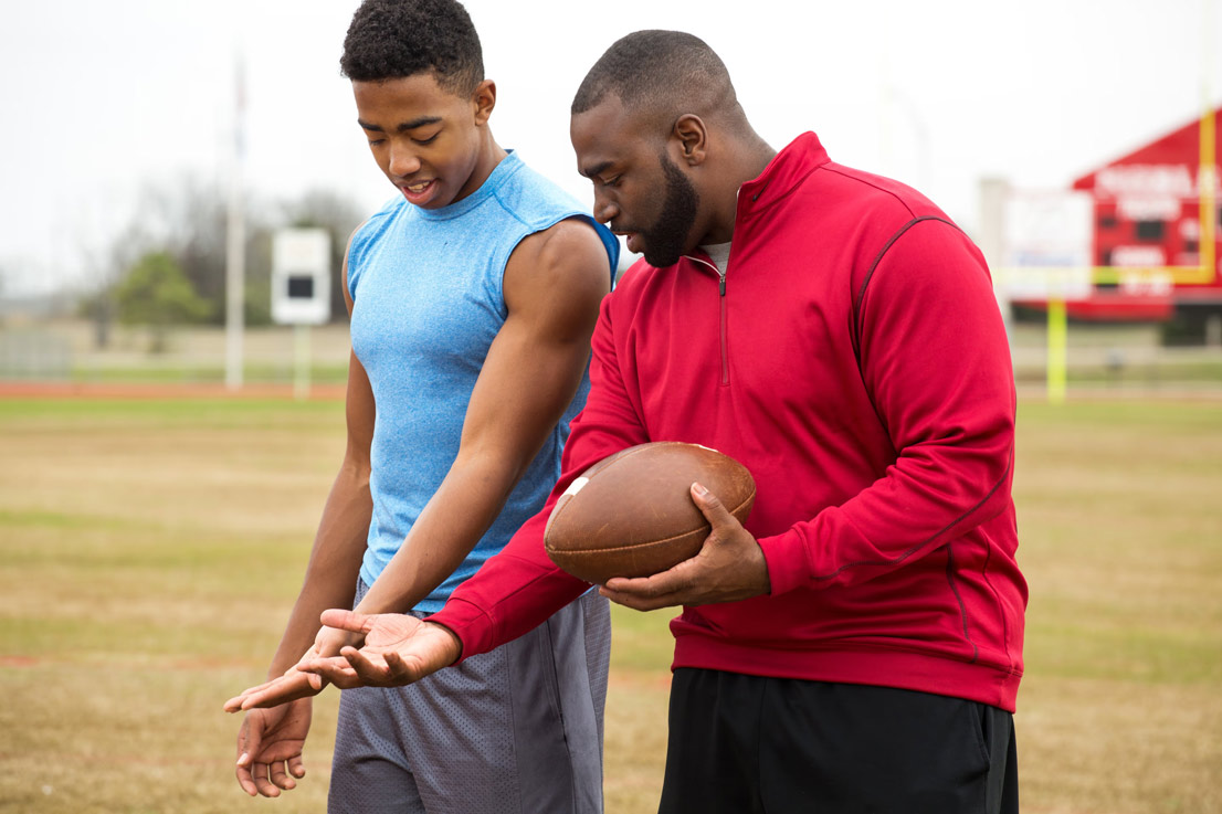 A father and son playing football together