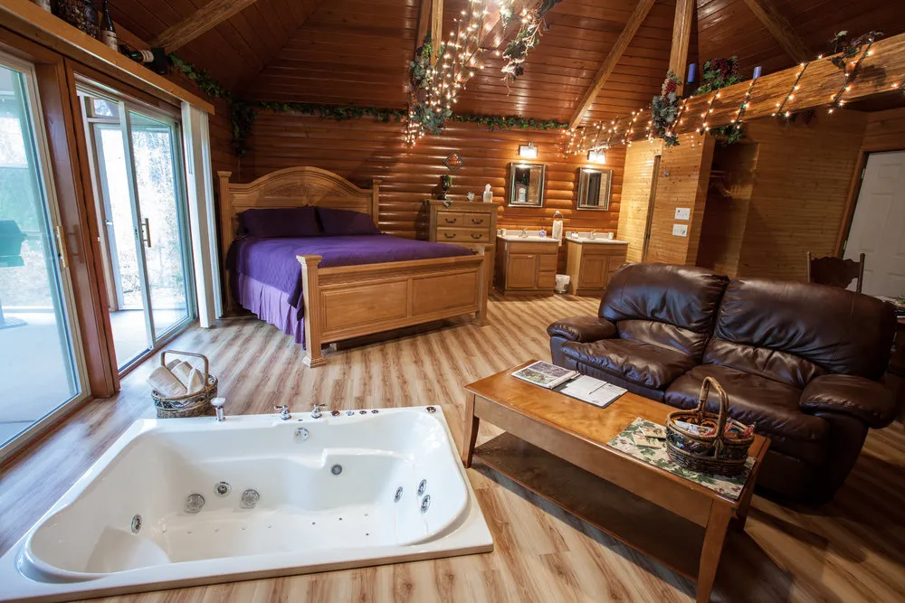 Cabin interiors with sunken tub for two, king sized bed and living area.