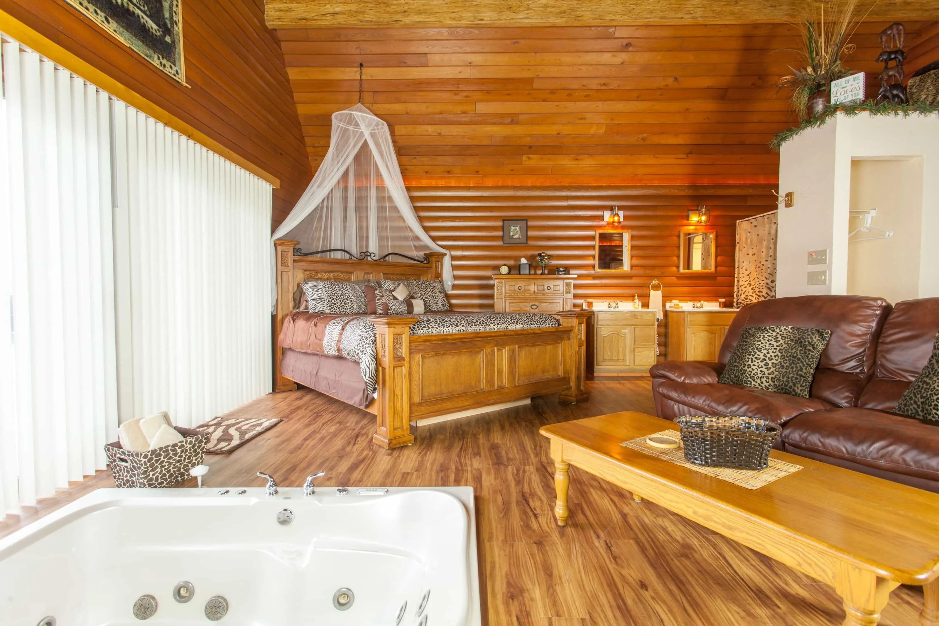 The main room of a cabin with rustic furniture and a sunken whirlpool tub.