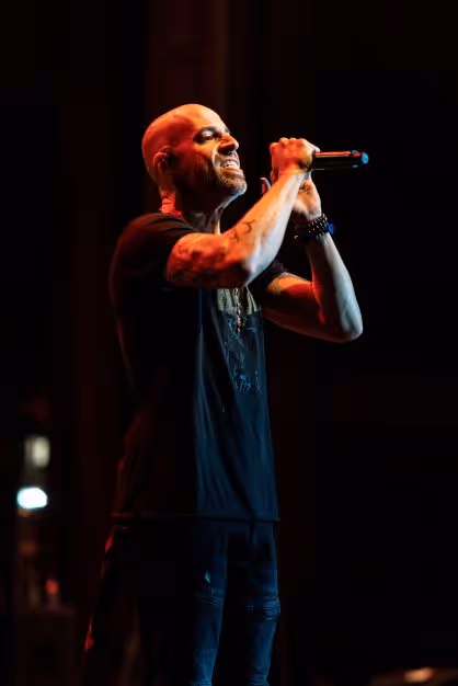 Daughtry singing passionately into a microphone held with both hands. 