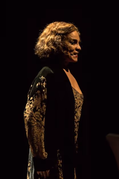 Jasmine Guy performing passionately, a look of determination on her face. 