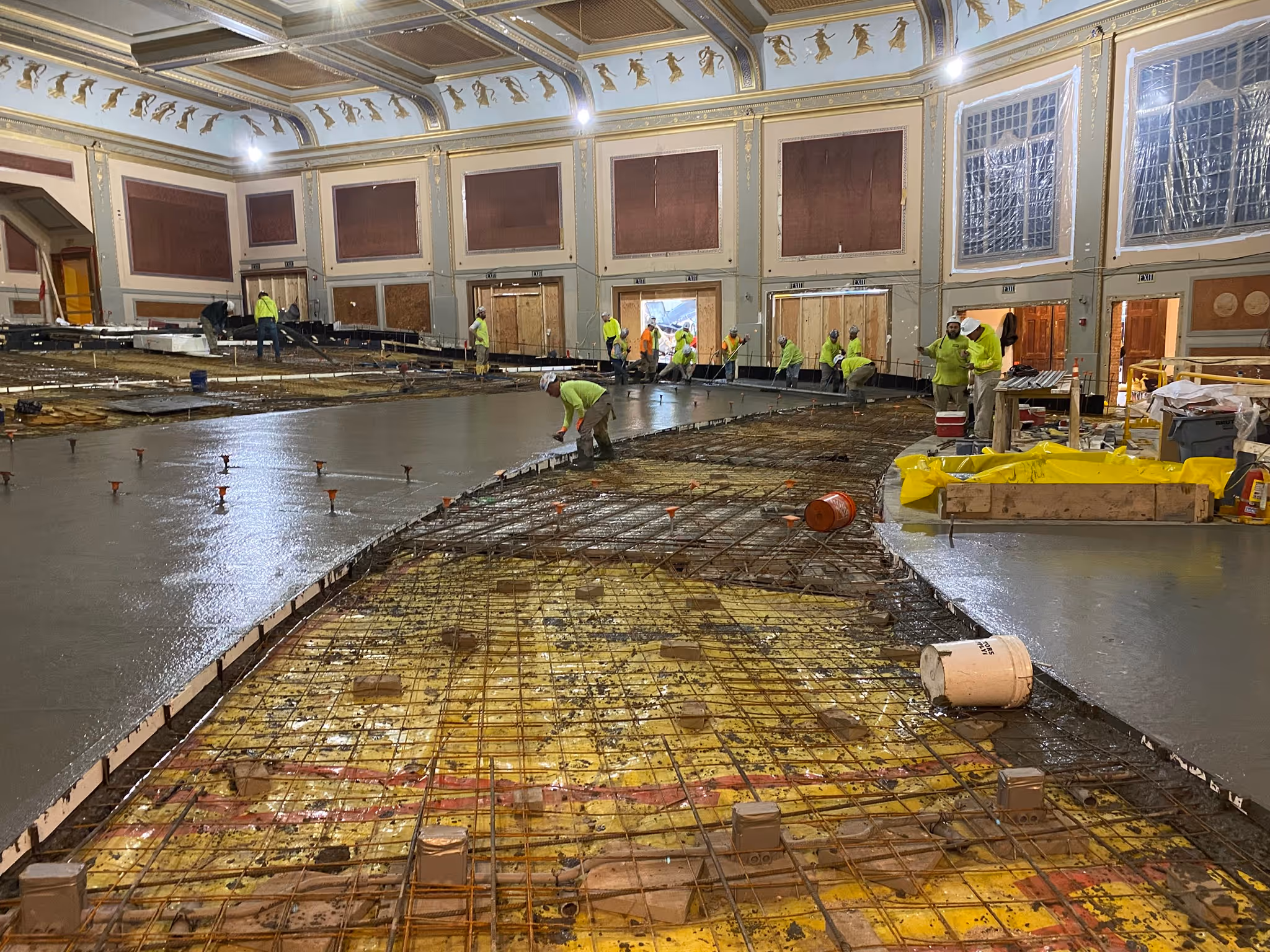 The interior of the Zeiterion theater, while under construction. Sections of the concrete floor have been freshly poured and metal support structures can be seen between the poured floors.