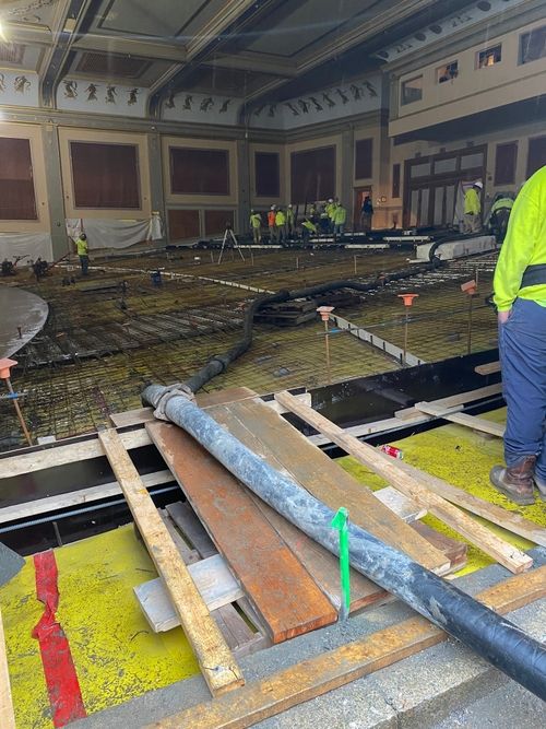 The interior of the Zeiterion theater. Construction workers are in progress of pouring the concrete floor in the far corner.
