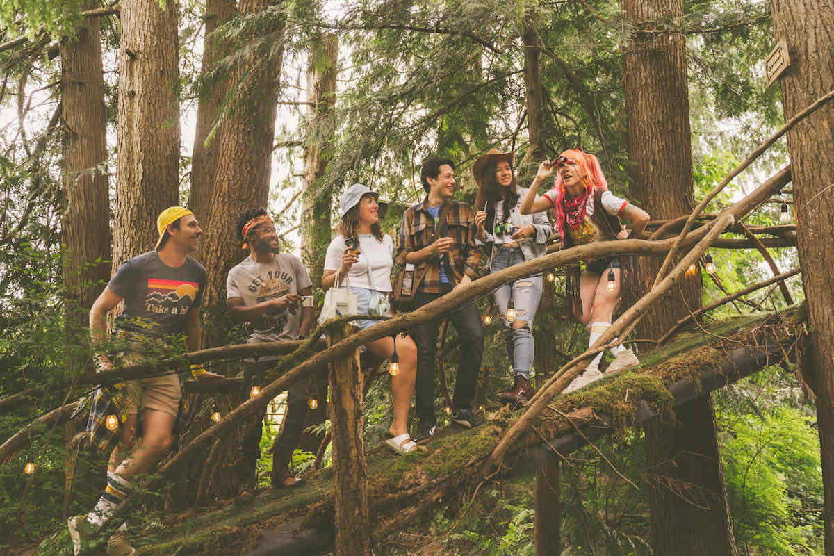 Friends in a treehouse strung with lights