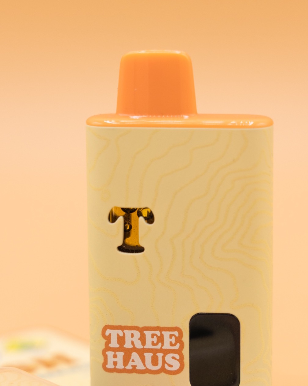 The TreeHash all-in-one standing upright: cream body with Mt. Rainier topo lines, orange mouthpiece and a brown T mark