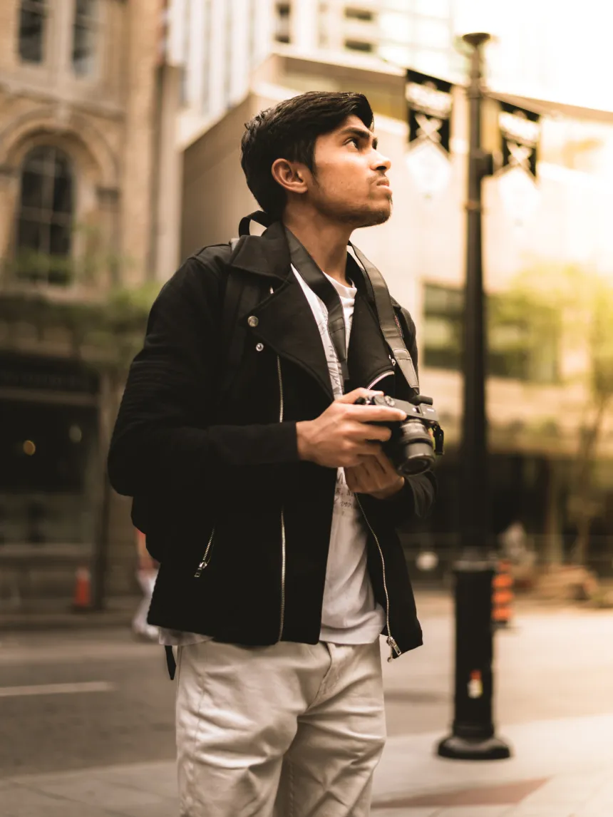 Vinit holding a camera while posing