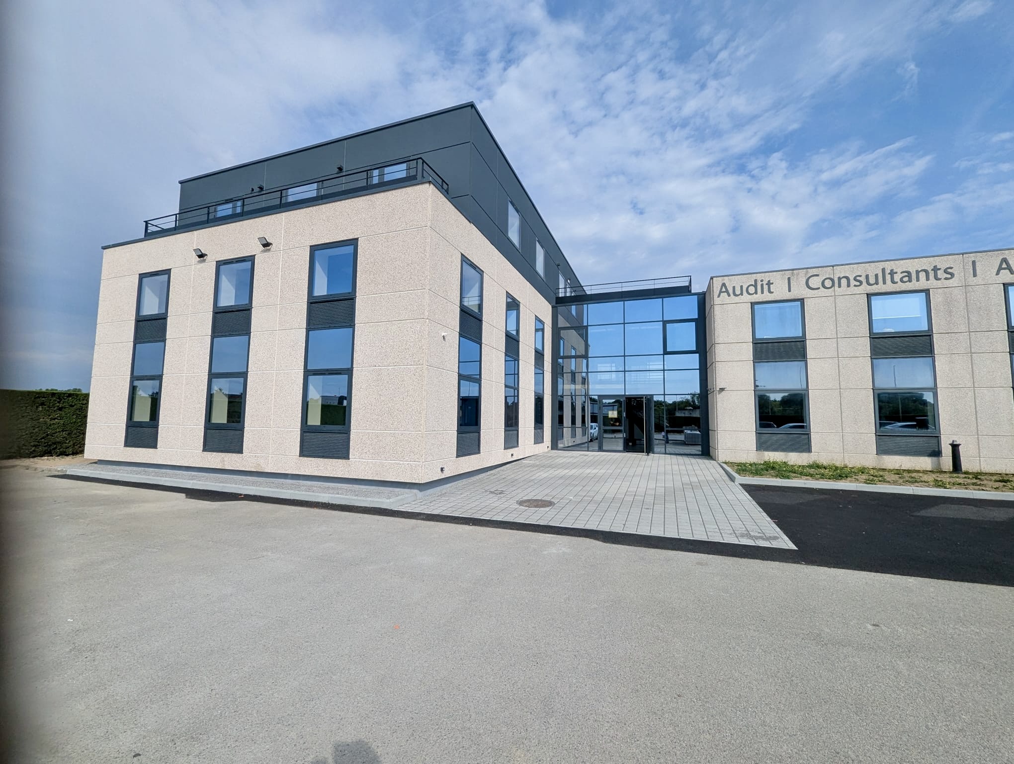 Façade beige désactivé blanc du bâtiment TGS à Nantes avec terrasse étage supérieur et fenêtres gris-bleu
