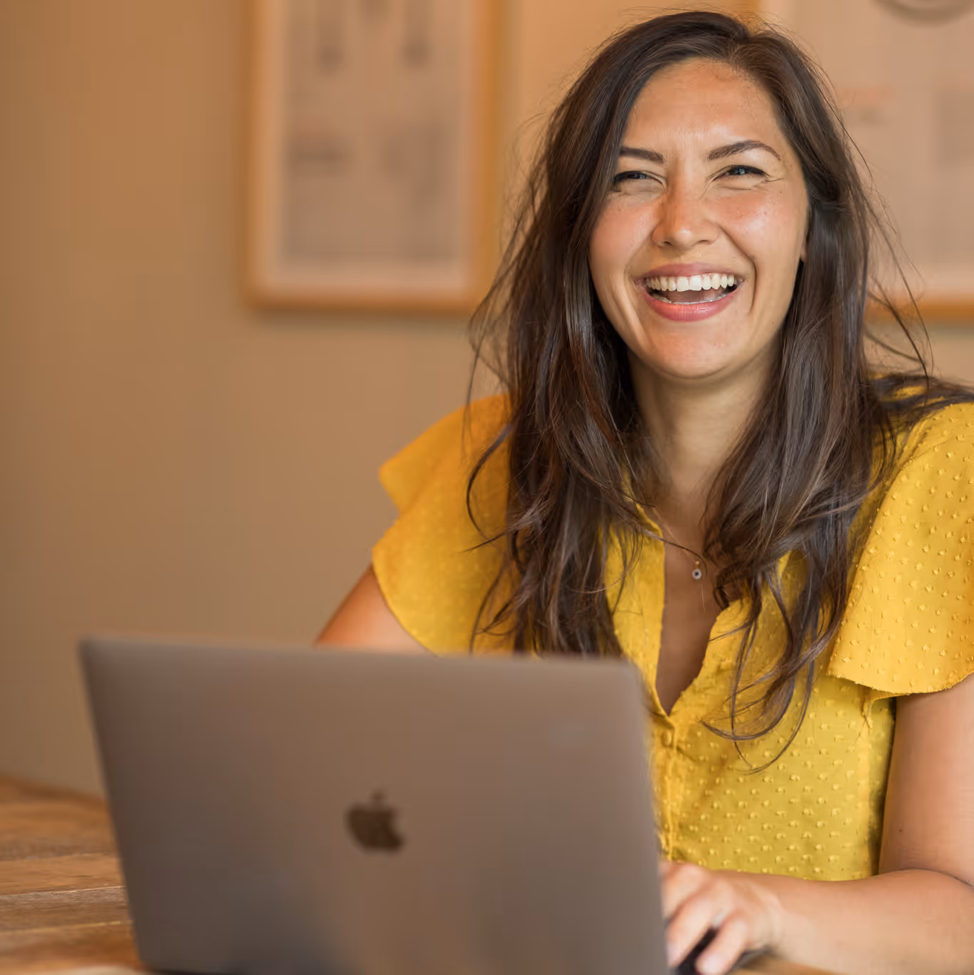 Smiling woman in front of laptop looking into the camera