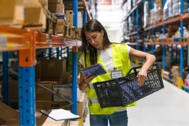 Woman picking an item in a warehouse