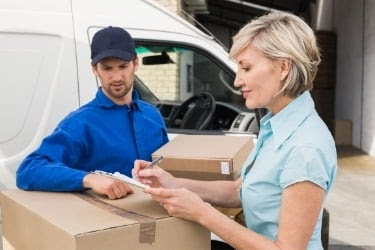 Woman receiving delivery and signing papers