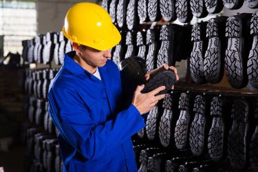 Man doing quality control on shoes warehouse