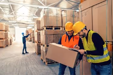 two warehouse workers talking about work
