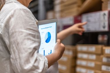 Woman identifying low-demand items with a Warehouse management system