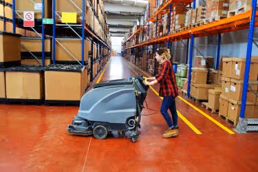 Woman cleaning the floors of the warehouse