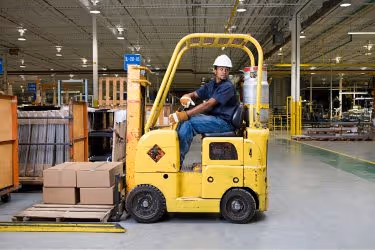 Forklift driver moving boxes