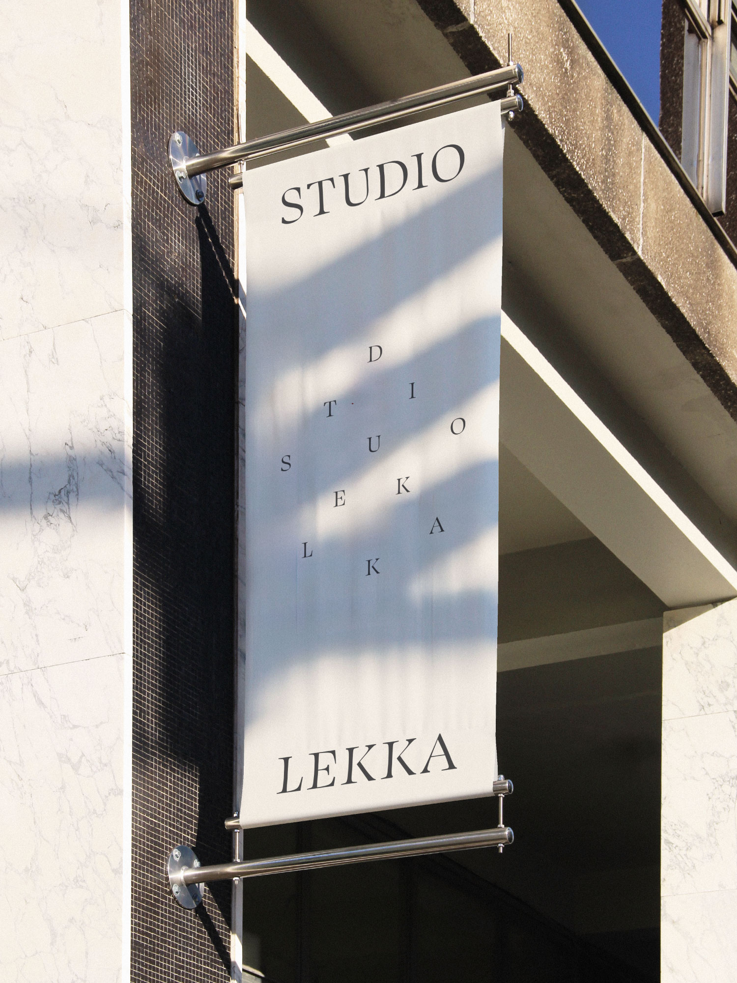 A Studio Lekka blade sign hanging from a stone façade.