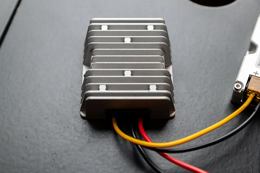 Close up on a small metal box with several wires coming out of it