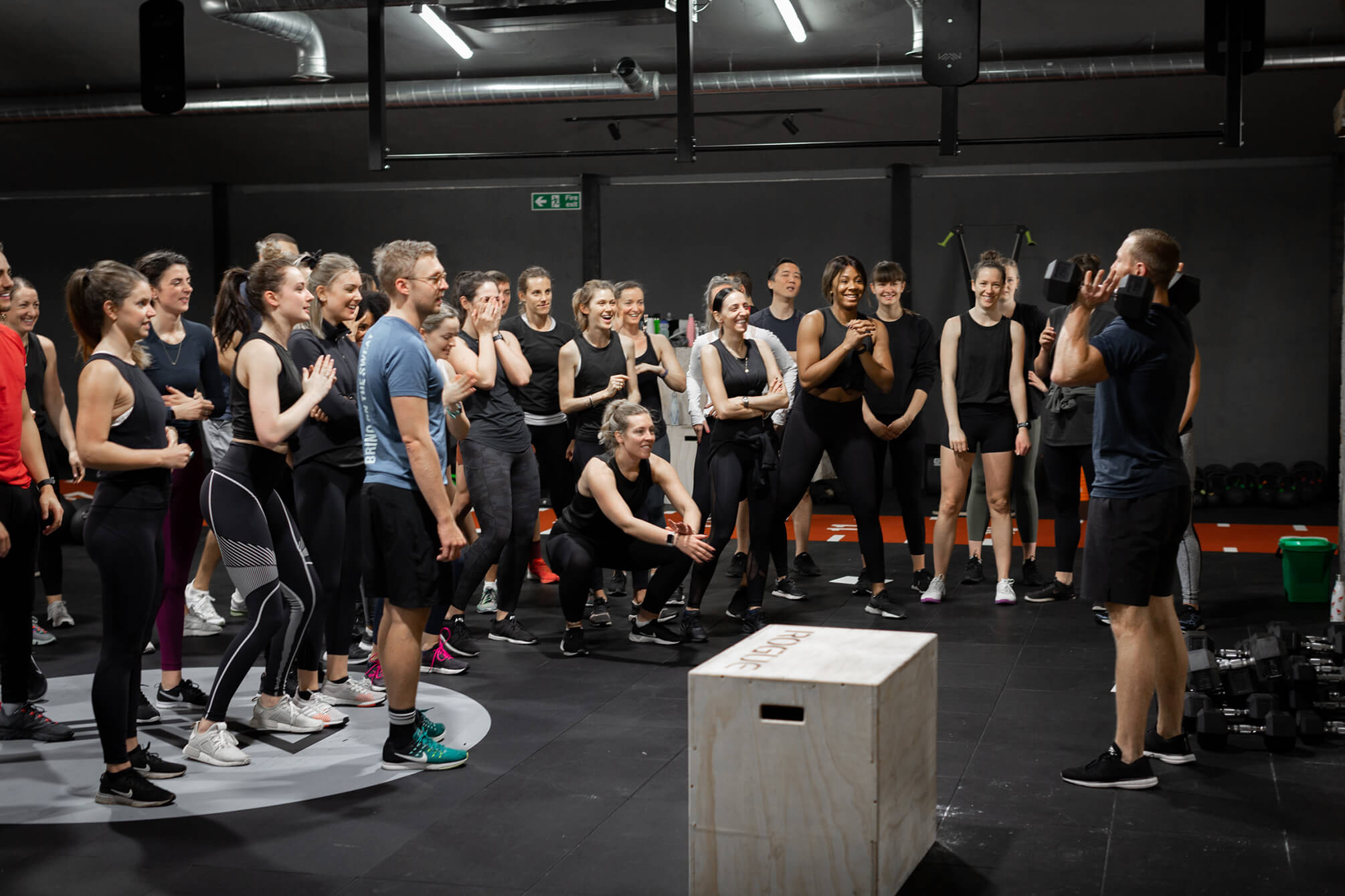 A group a people being coached on the gym floor.