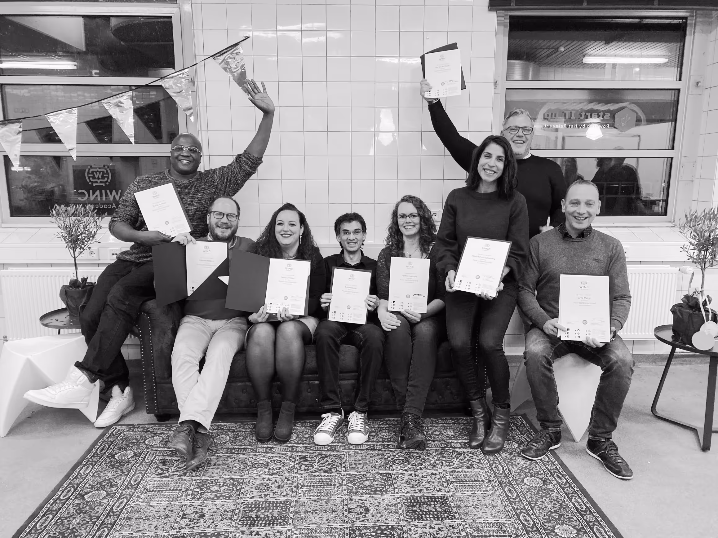 Groep afgestudeerden met hun certificaat bij Winc Academy