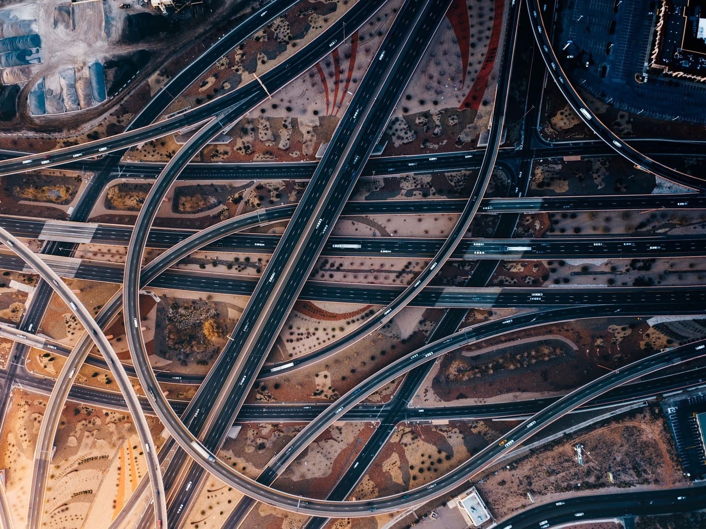 Drone image of many roads and overpasses winding past each other with vehicles travelling on them.