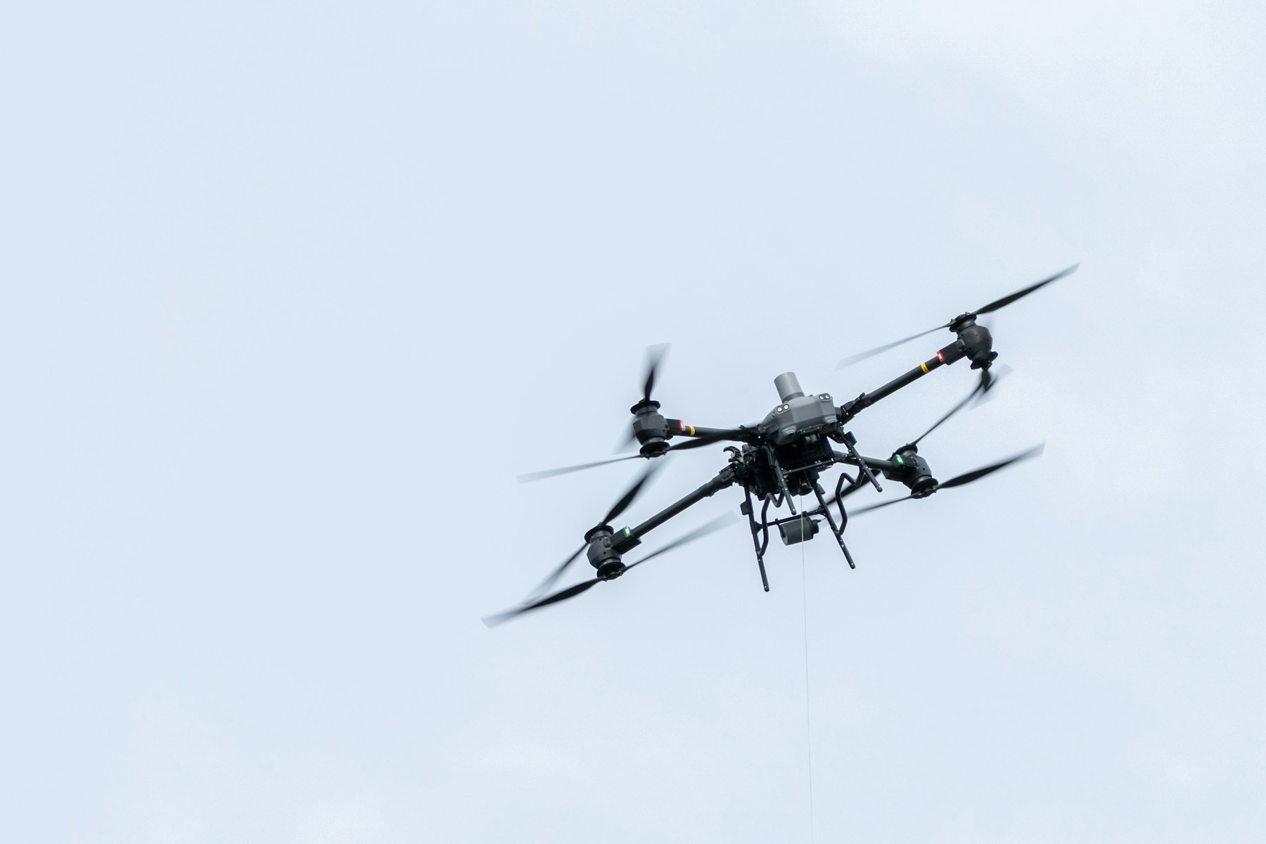 Industrial drone flying against a pale sky