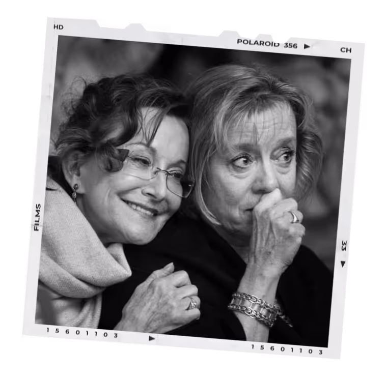 Black and white photo of two older women, one smiling and comforting the other who looks worried.