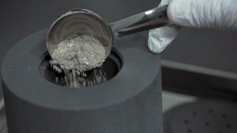 Carbon graphite powder being poured.