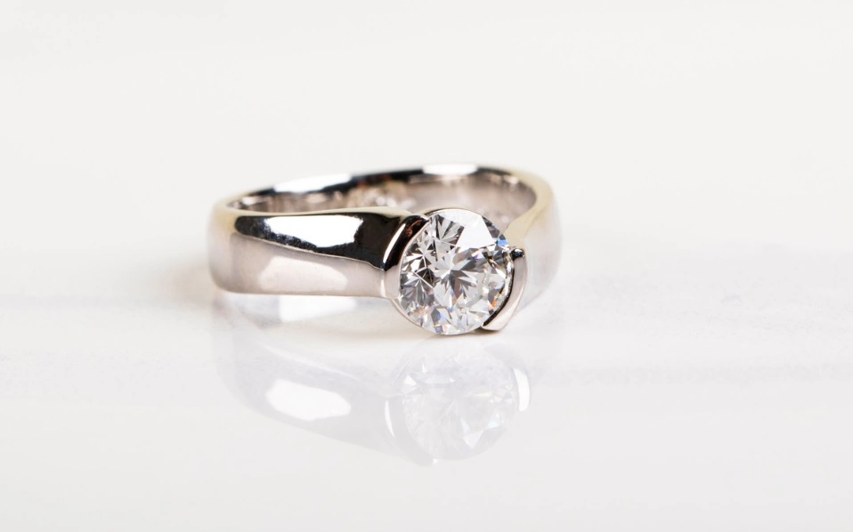 Silver ring with colorless round diamond.