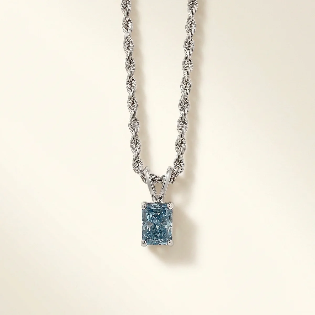 A 1ct blue rectangular radiant diamond on a white gold necklace, custom-designed by Eterneva to honor the remarkable Senthil.