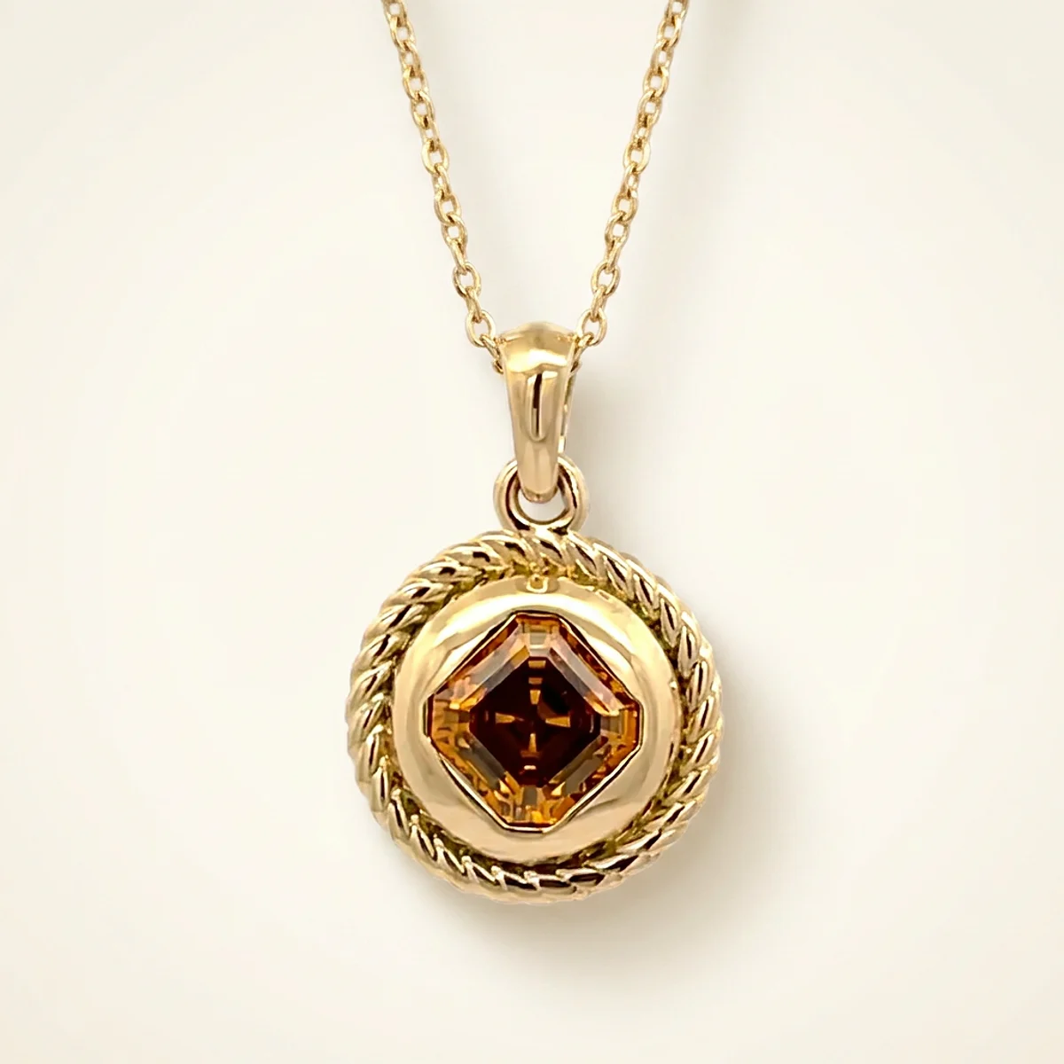 A .4ct amber asscher diamond on a yellow gold pendant, custom-designed by Eterneva to honor the remarkable Tyson.