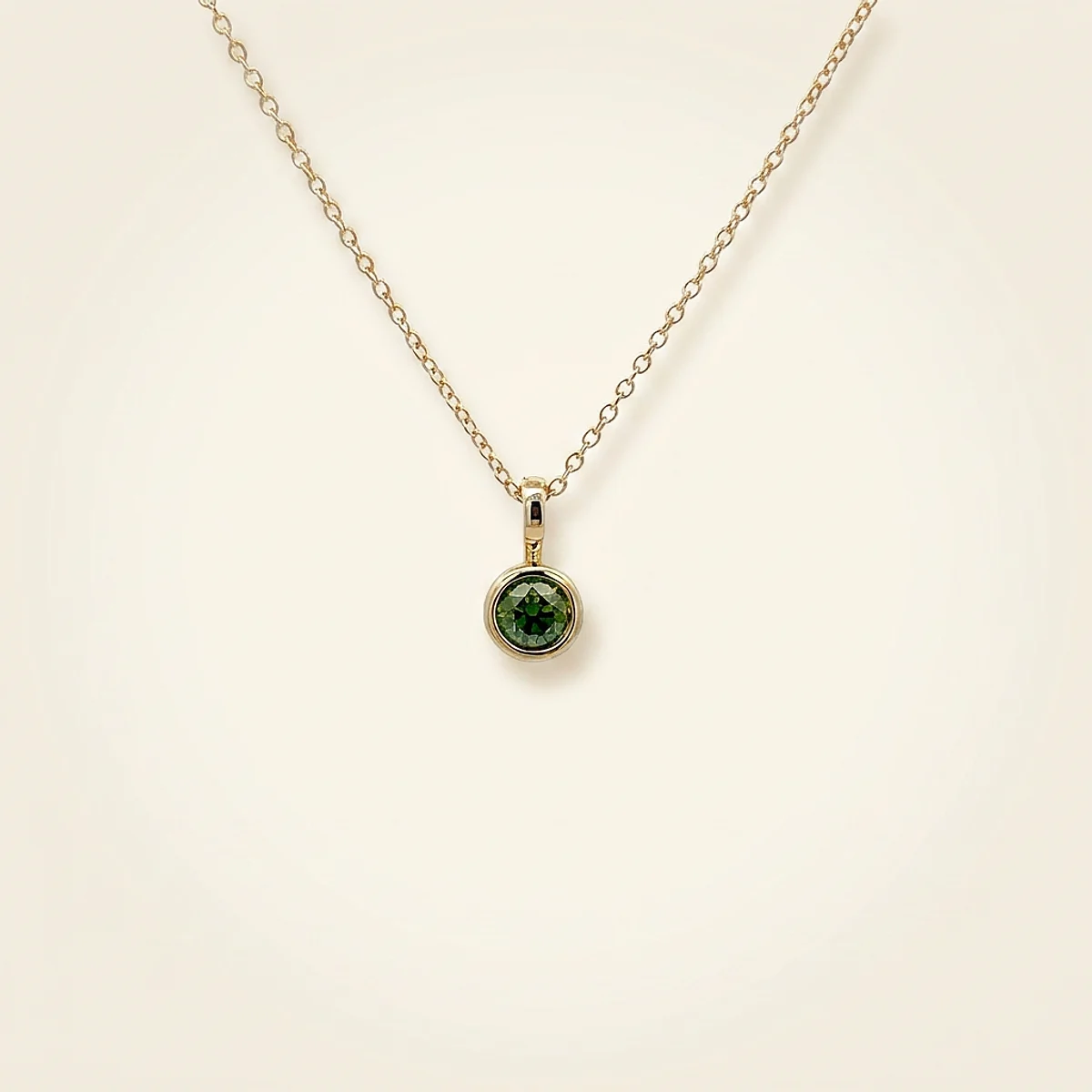A .25ct green round diamond on a yellow gold pendant, custom-designed by Eterneva to honor the remarkable Warren.
