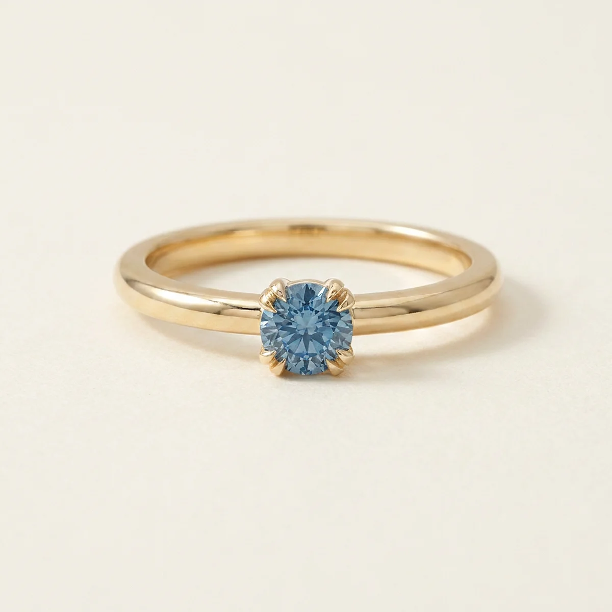 A .25ct blue round diamond on a yellow gold ring, custom-designed by Eterneva to honor the remarkable Nancy.