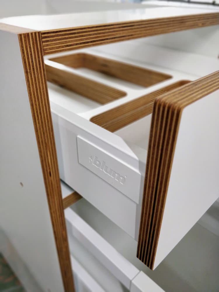 White drawer front and cabinet frame with exposed plywood edges.