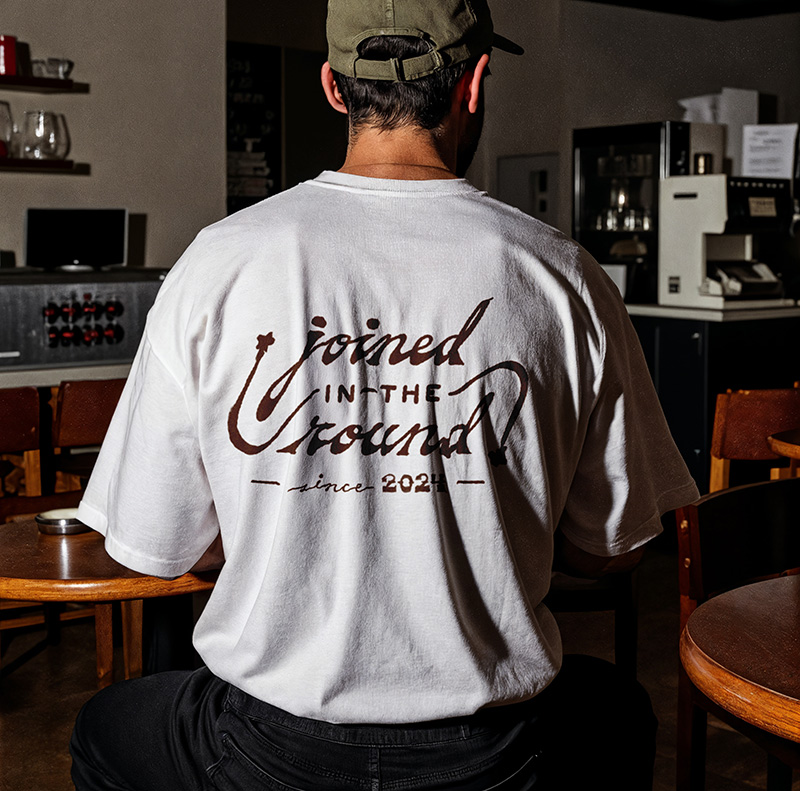 Mockup of Magic Loop t shirt from the back in a cafe.
