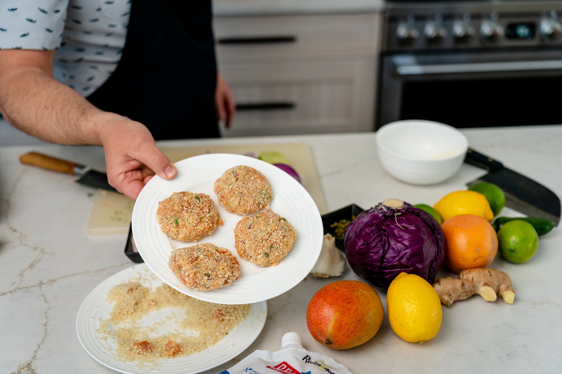 Formed salmon cakes coated in panko on a white plate