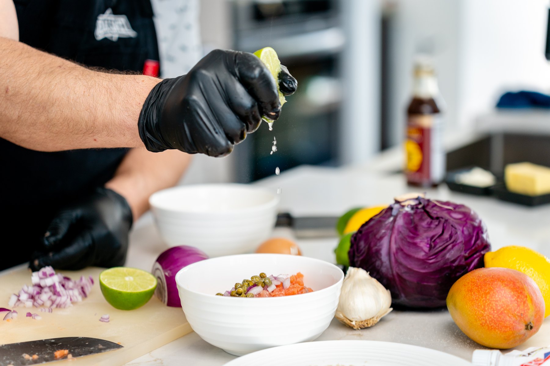 Squeezing lemon over a bowl of chopped salmon and capers