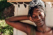 A woman relaxing in her backyard on a hammock