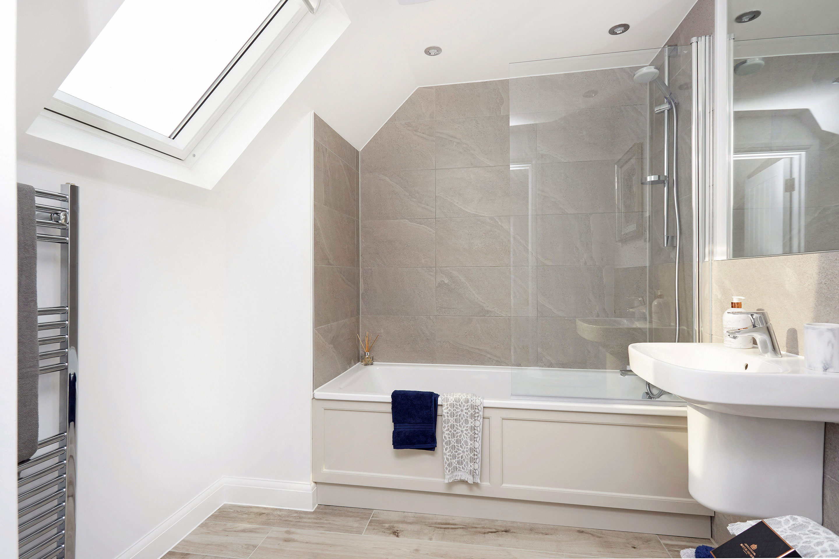 Smart bathroom with skylight, metal radiators and grey tiles