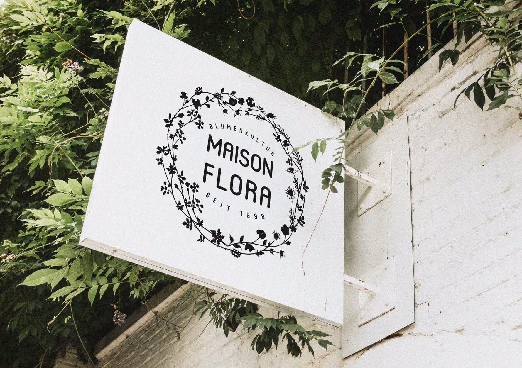 Geschäftsbeschilderung mit floralem Logo von Maison Flora