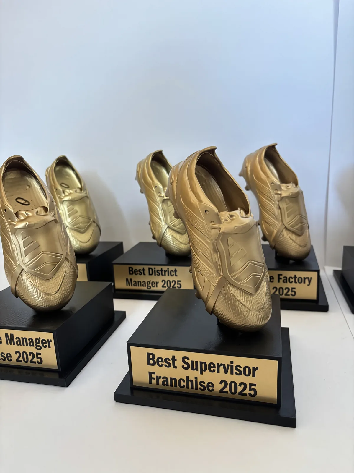 Trofeos corporativos con forma de zapatilla dorada impresos en 3D en Ciudad de México