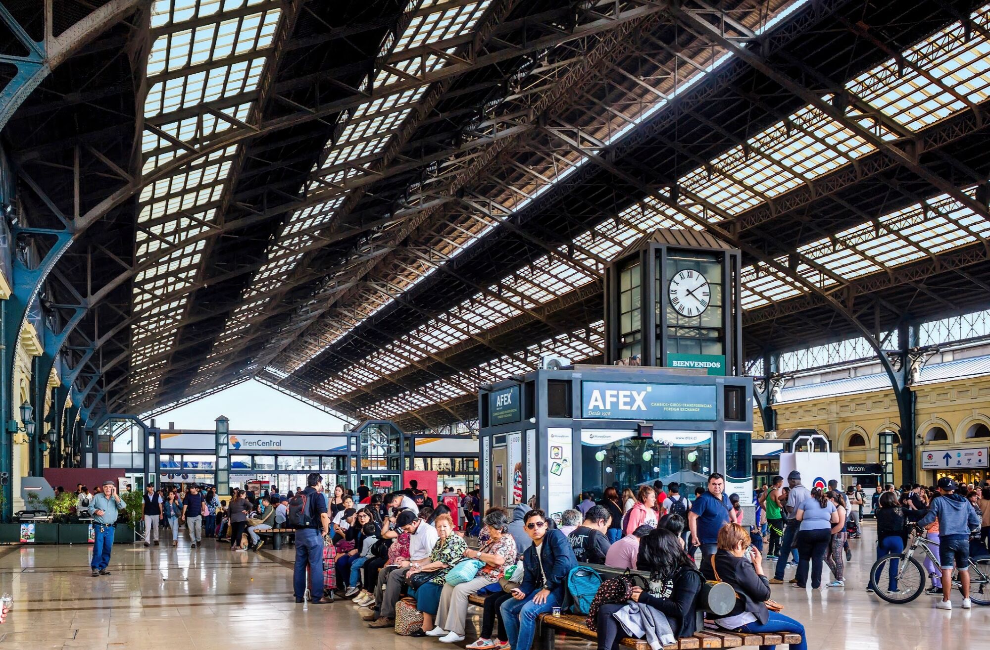 Passengers waiting inside the historic glass-and-steel interior of Santiago Alameda Railway Station in Chile.