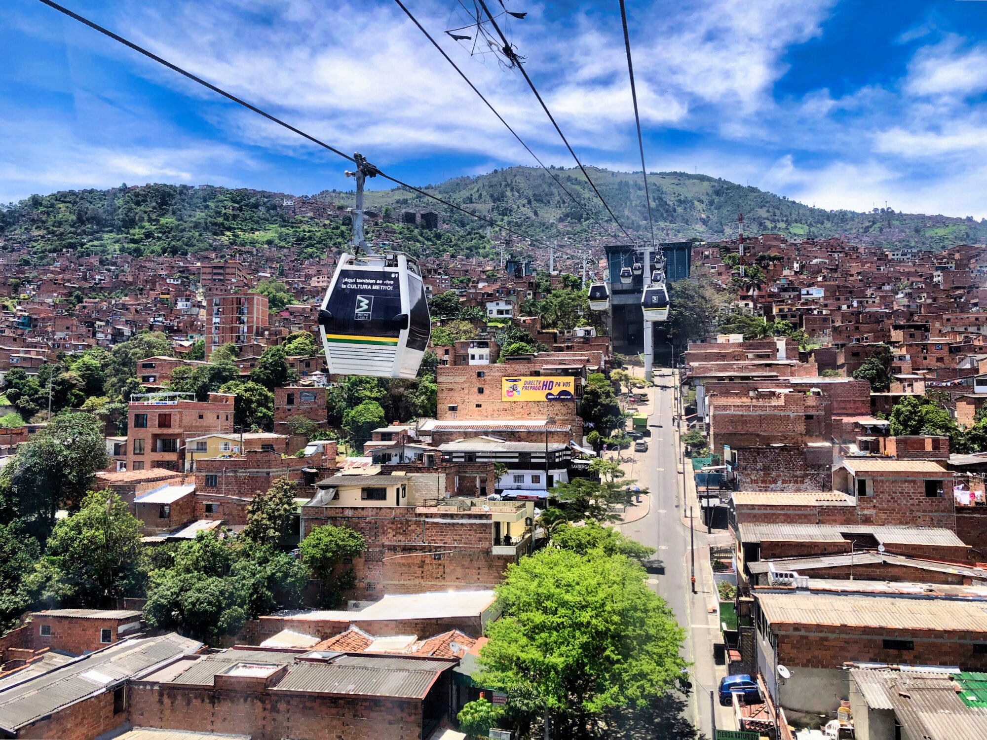 Metrocable cabins traveling above hillside neighborhoods in Medellín, Colombia.