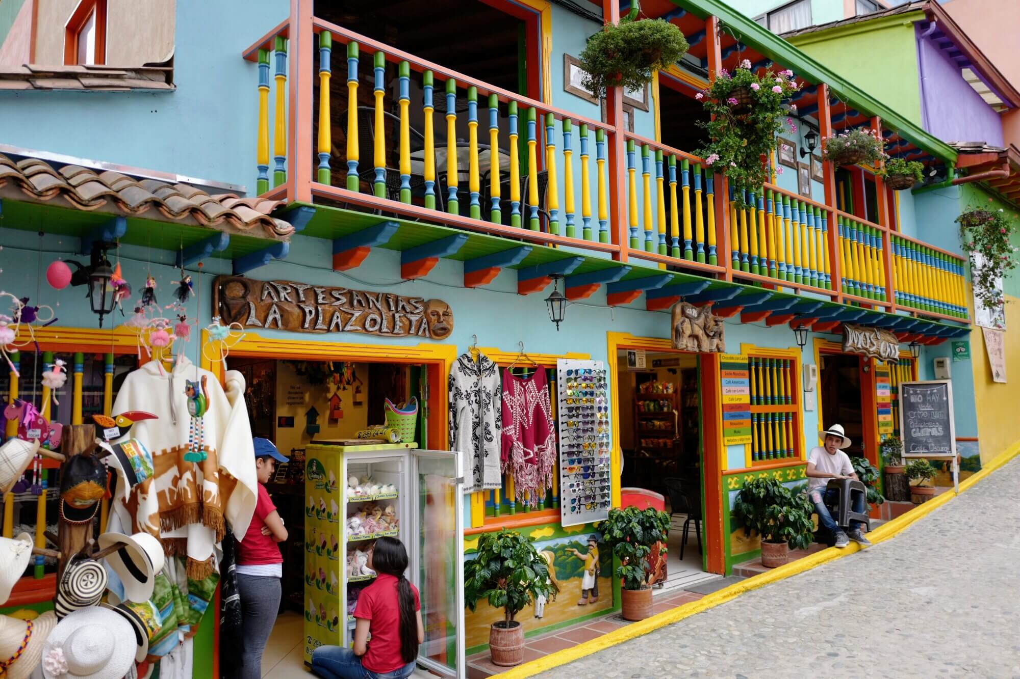 Colorful artisan shop with a painted façade and traditional balcony in Guatapé, Colombia.