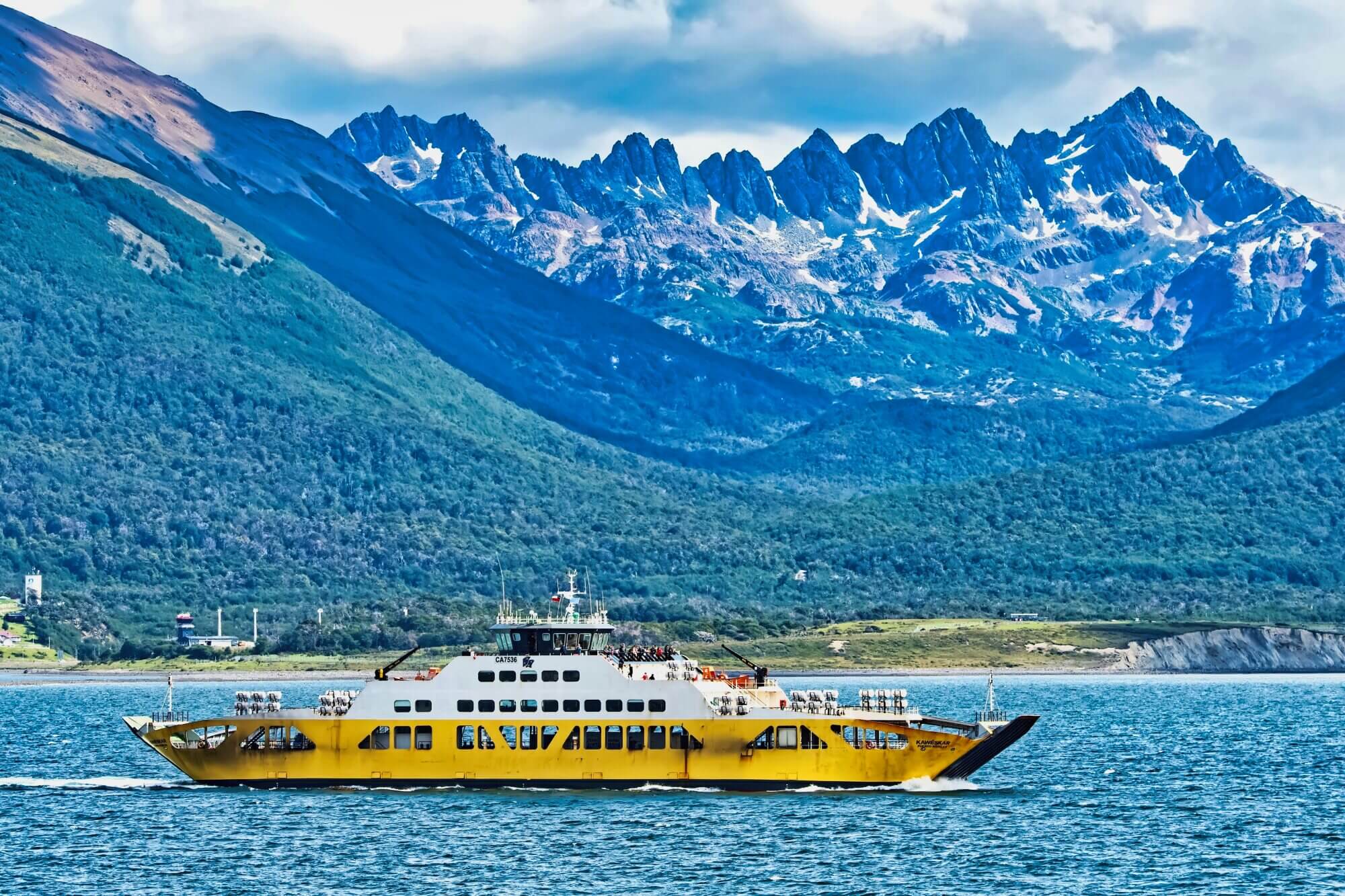 Passenger ferry on the waters of Tierra del Fuego with snow-covered mountains in the background