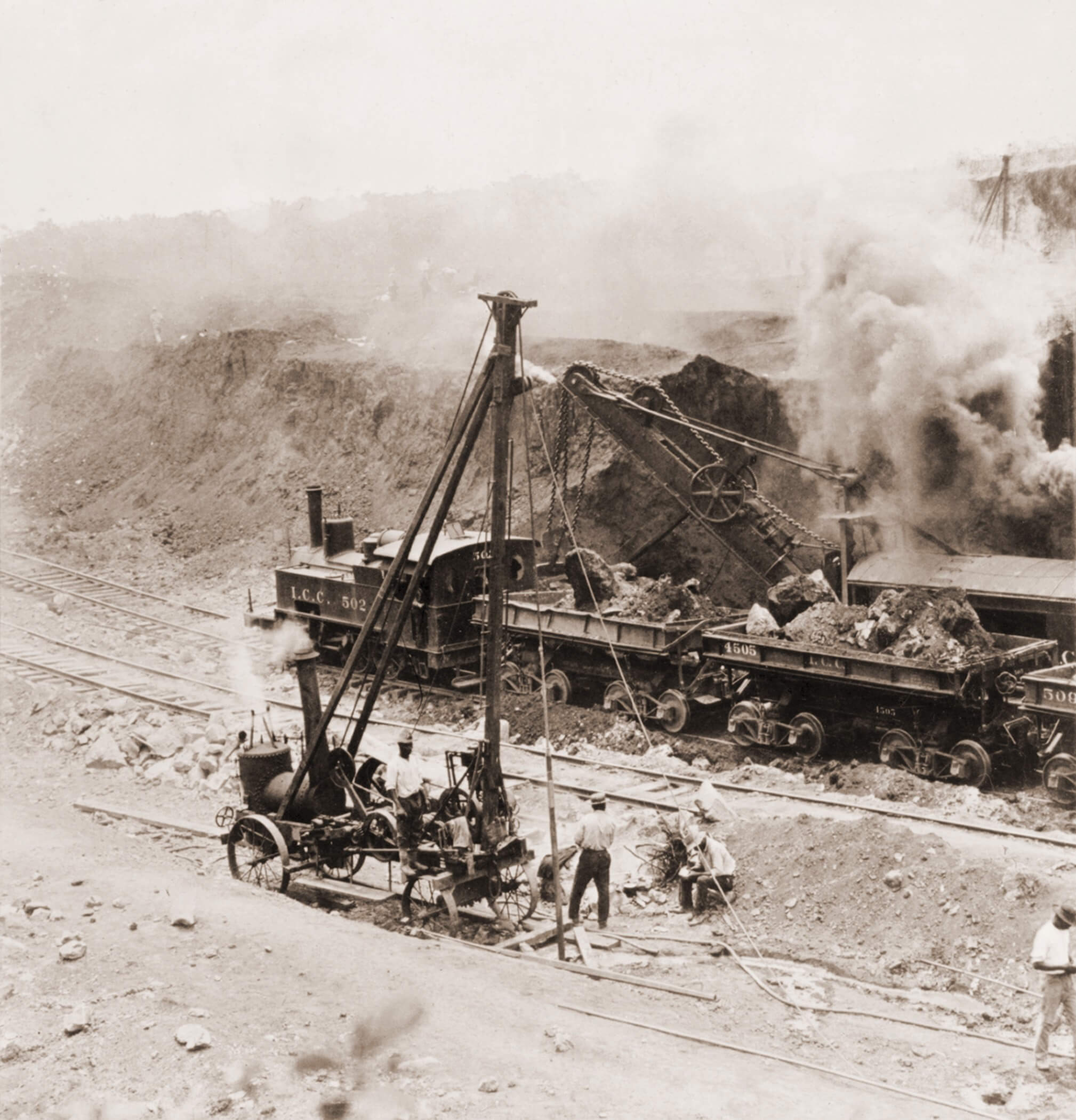 Steam excavation equipment loading rock and earth into railway wagons during construction of the Panama Canal.